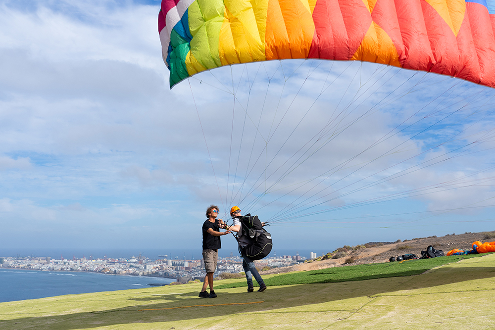 Woman with instructor flying on parachute against sky Escuela de Vuelo - Imagen 1